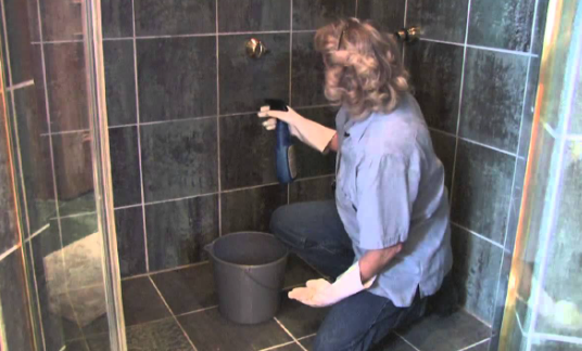 A women cleaning a bathroom tile 