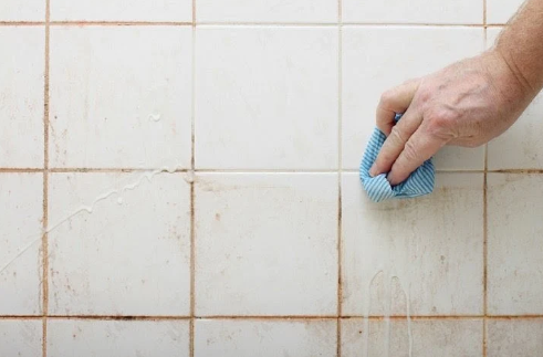 a women cleaning the tile with vinegar
