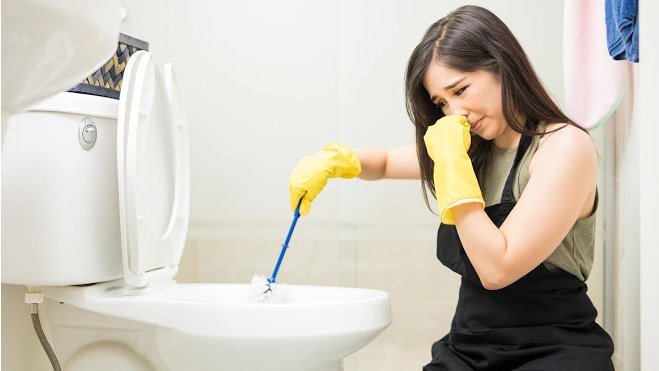 A girl is cleaning the bathroom